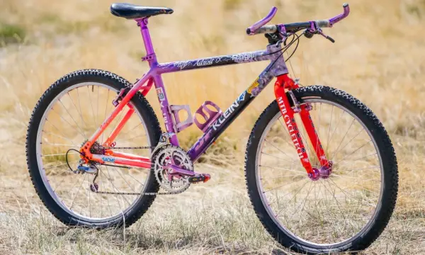 A vibrant Klein Adroit mountain bike with purple and orange fade paint, ready for an adventure.